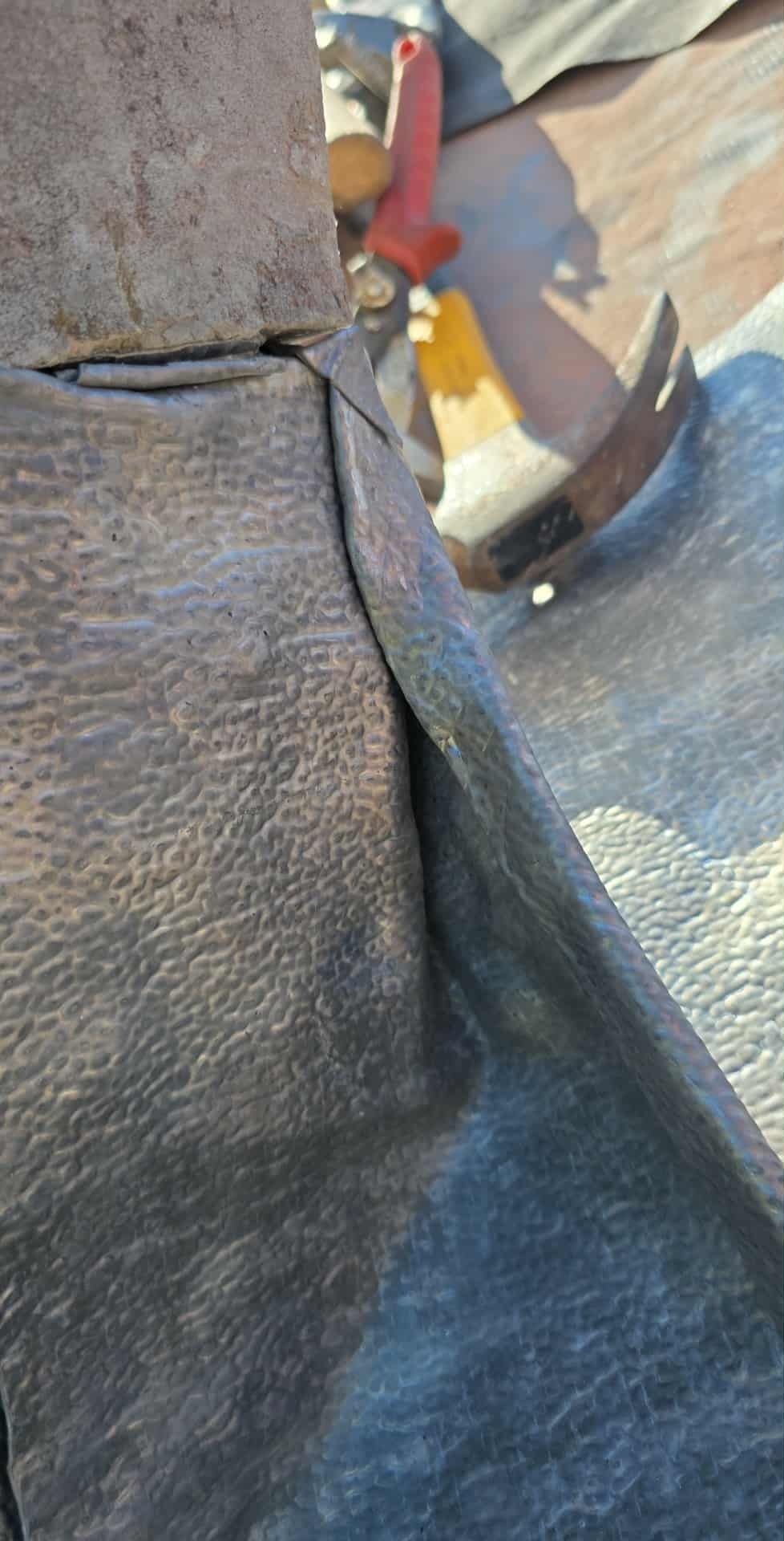 Close view of metal roof flashing and seam work
